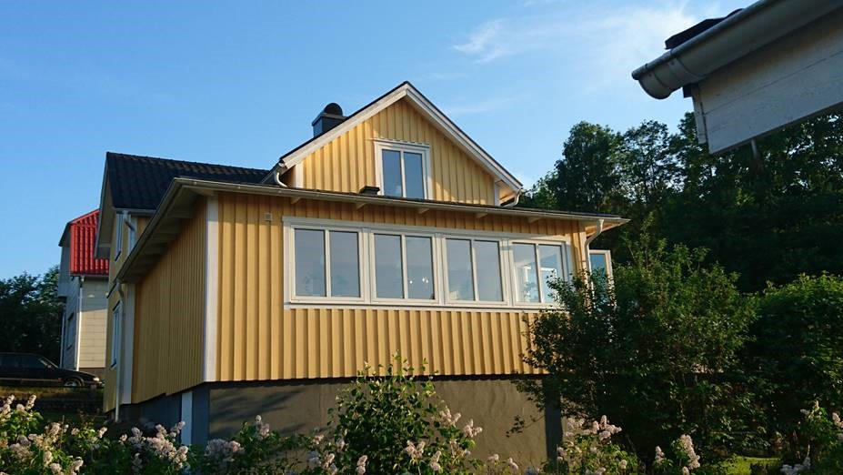 Gult trähus med stående panel i Bengtsfors