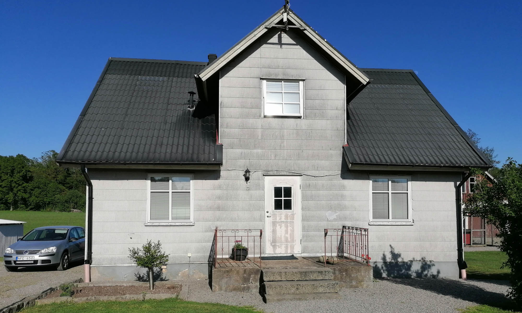 Tvåvåningshus med grå eternitplattor på fasaden